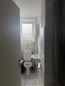 a small bathroom with a toilet and a sink at K&K Unterkunft Gelsenkirchen in Gelsenkirchen