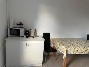 a small kitchen with a table and a microwave at K&K Unterkunft Gelsenkirchen in Gelsenkirchen