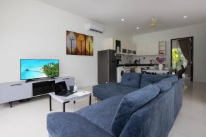 Ban Saiyuan (1)にあるPrivate Pool Villa 2BR near gym and spa - Villa Green 9の青いソファとテレビのあるリビングルーム