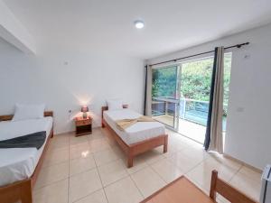 Un dormitorio con dos camas y una gran ventana. en Residencial Mãe Nona, en Ribeira Grande