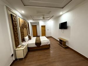 a hotel room with a bed and a television at Grand Royal Hotel in Lahore