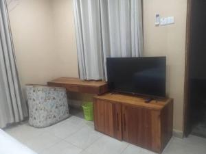 una TV su un supporto in legno in una stanza di Salt Garden Inn a Dar es Salaam