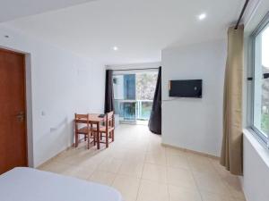 Ribeira GrandeにあるResidencial Mãe Nonaのベッドとテーブルと窓のある寝室