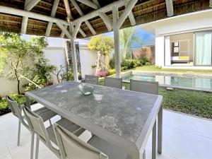 格兰贝伊Dream villa with pool的庭院里的一张混凝土桌子和椅子