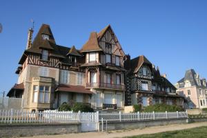 una grande casa con una recinzione bianca di fronte di Sphinx Résidences - Tempologis Mémorial a Caen
