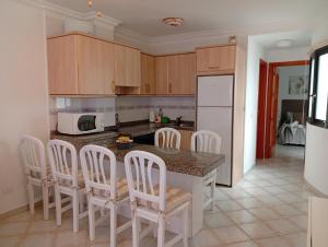 a kitchen with a table with chairs and a counter top at Susurro del Mar - Relax Apartment in La Restinga in La Restinga