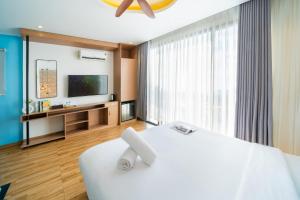 a bedroom with a large white bed and a tv at Seavista Apartment Da Nang in Da Nang