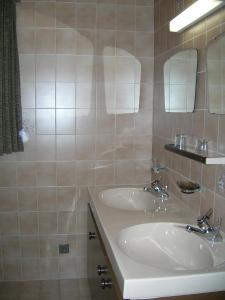 a bathroom with two sinks and a mirror at Riedhof in Mieders