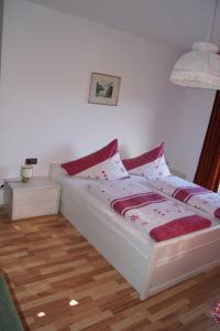a bedroom with a bed with red and white sheets at Riedhof in Mieders +3 photos