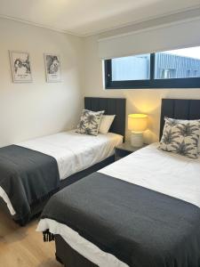 ヘルマナスにあるCentral Town Duplex with Pool, BBQ & Mountain Viewのベッド2台と窓のある寝室