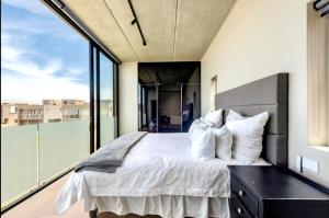 a bedroom with a large bed and a large window at Keursands Luxury Beachside Holiday Escape in Keurboomstrand