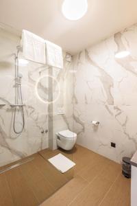 ein weißes Badezimmer mit Toilette und Dusche in der Unterkunft Stella Maris Beach in Razvala