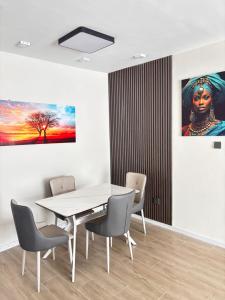 a dining room with a table and chairs and a painting at Stay with queen in Marimbeti