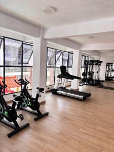 a gym with several treadmills and exercise bikes at Stay with queen in Marimbeti