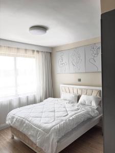 a bedroom with a large bed with white sheets at Stay with queen in Marimbeti +6 photos