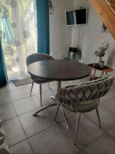 a table and two chairs in a living room at La Suite 27 bis, maison indépendante avec terrasse, proche gare et centre in Guingamp