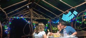 a group of people sitting at a table with food at Relax Nature Villa in Sigiriya