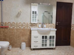 Un baño con lavabo e inodoro en Sheyllo Suites Abidjan - Cocody, en Abiyán 38 fotos más