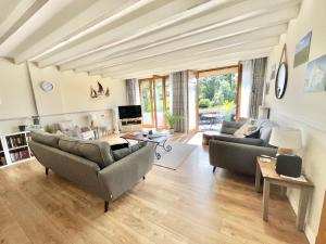 a living room with two couches and a tv at Quai du Val is a Charming Pet and Family Friendly Riverside Gite in Lehon close to Dinan Sleeps 7 in Dinan