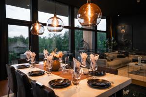een eettafel met stoelen en een groot raam bij NEW luxury villa by the river in Rovaniemi