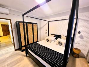a bedroom with a black and white canopy bed at Mana Suites Bali in Kuta +19 photos