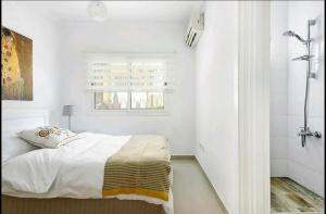 a white bedroom with a bed and a window at Amazing Sea View -3 Bed Ground Floor Garden Apartment in Kérynia