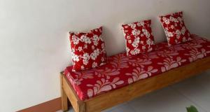 Un sofá rojo con dos almohadas rojas encima. en Enjoy and have fun while having your vacation, come book this place, en Bayawan