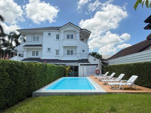 a house with a swimming pool in front of a house at Mini-Me HUBS, Charm Suites & Pool in Old City in Chiang Mai