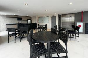 a dining room with tables and chairs and a kitchen at Hub Residence Intermares 3 Pessoas TV WI-FI in Ilha da Restinga