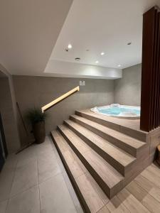 a swimming pool with a stairs leading to a swimming tub at RESORTLuxurySPA in Wrocław