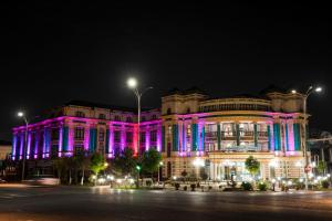 a building is lit up in pink and purple at Bogishamol Hotel in Andijan