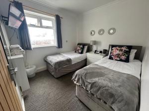 a bedroom with two beds and a window at Sandford Promenade in Blackpool
