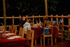 a group of people sitting at a table in a restaurant at Samora River Lodge in Kioga