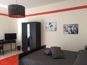 Schlafzimmer mit einem Bett und einem Schreibtisch sowie Bildern an der Wand in der Unterkunft B&B Napoli Napoli in Neapel