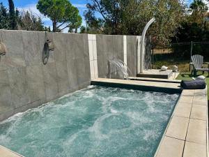 a swimming pool with a fountain in a backyard at Mas de l Aire in Corneilla-del-Vercol
