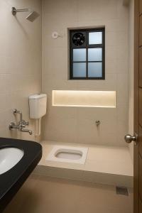プネにあるManas lake Hideaway 2 BHK Homestayの洗面台と窓のあるバスルーム
