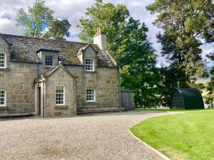 ein altes Steinhaus mit Kieseinfahrt in der Unterkunft Sherrabeg Cottage in Laggan