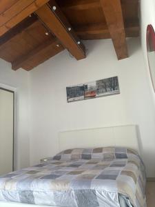 a bedroom with a bed and a wooden ceiling at La casetta di San siro in Milan