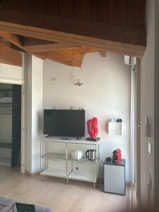a living room with a television on a white shelf at La casetta di San siro in Milan