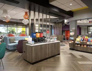 a lobby of a store with a counter and chairs at Tru By Hilton Grimes Des Moines in Grimes