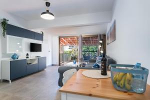 a kitchen and living room with a wooden table at Apartamentos Romandie by Saratur in San Bartolomé de Tirajana
