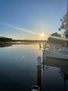 ein Boot, das in einem Yachthafen mit Sonnenuntergang angedockt ist in der Unterkunft RIVERBANK COTTAGE in Sussex inlet
