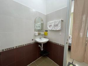 ein Badezimmer mit Waschbecken und Spiegel in der Unterkunft Tụi Mình homestay in Thôn Trường Giang