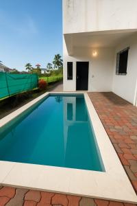 a swimming pool in front of a house at ll EMPYREAN STAY ll COCKTAIL VILLA ll 3BHK ll AC ll PRIVATE POOL ll in Lonavala