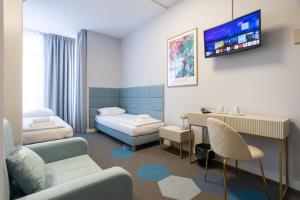 a hospital room with two beds and a tv at Moon ApartHotel in Wrocław