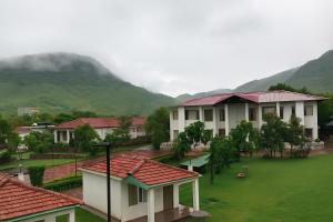 a group of houses with mountains in the background at Virat Resorts, Sariska Rajasthan in Bairāt