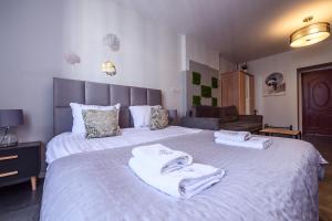 a bedroom with a large bed with towels on it at Loc8 Apartments by Cracovia Prime in Kraków