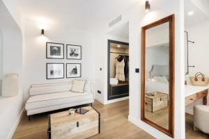 a living room with a white couch and a mirror at Hotel Inmood San Roque in Sotogrande
