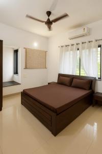 a bedroom with a bed and a ceiling fan at ll EMPYREAN STAY ll COCKTAIL VILLA ll 3BHK ll AC ll PRIVATE POOL ll in Lonavala