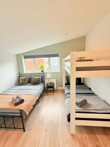ロンドンにある15 min to Central London Guest Suites 22の二段ベッド2台と窓のある寝室